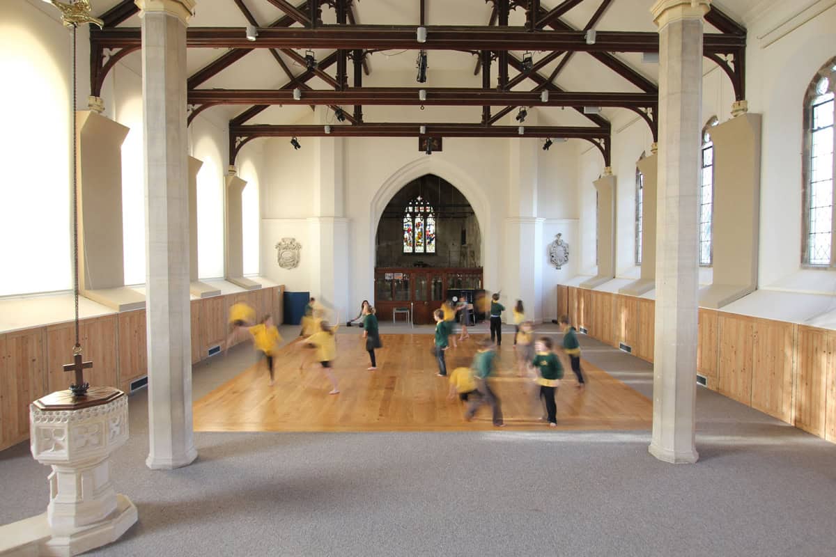 Horsley Church interior with children playing on oak floor beneath exposed timber roof trusses